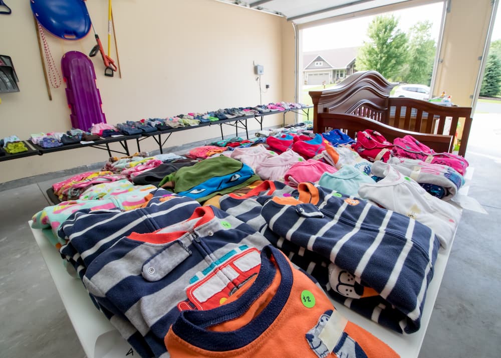 children's clothes set up on a table for a garage sale
