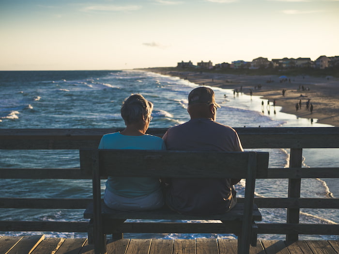 An elderly couple sits on a bench at Emerald Isle, NC.