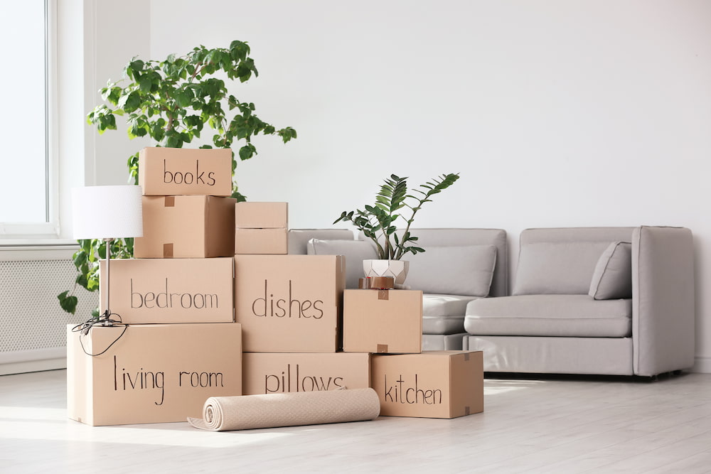 stacked and labeled boxes in a plain living room ready for moving 