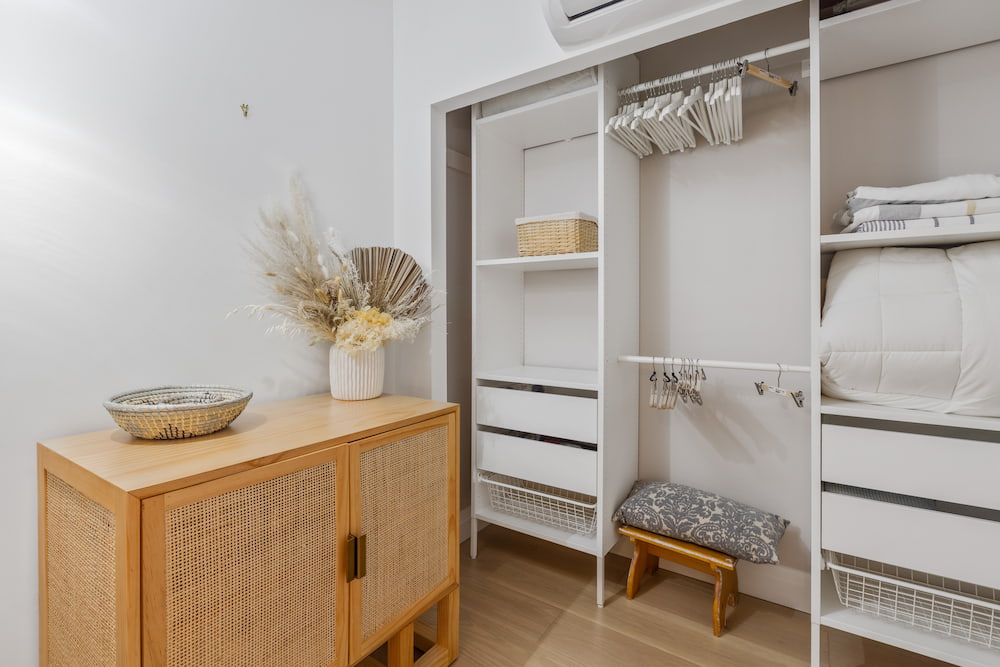 organized white closet with shelves, drawers and baskets