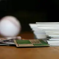 Stack of photos and a baseball.