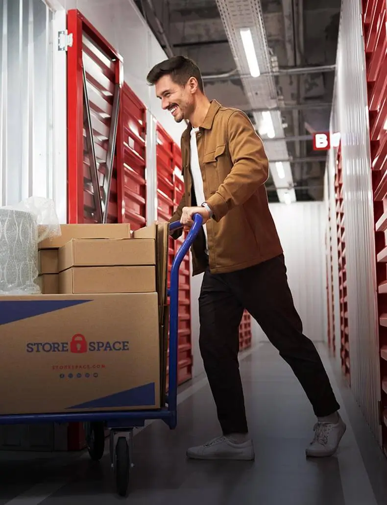 man pushing cart of store space boxes