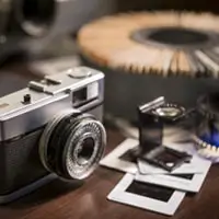 A film camera next to photos.