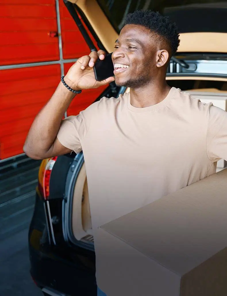 man talking on the phone holding a box