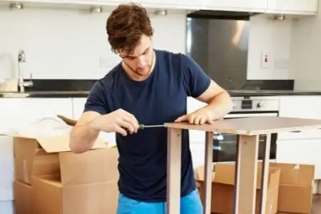man disassembling furniture