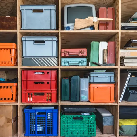 An organized shelf with storage containers.