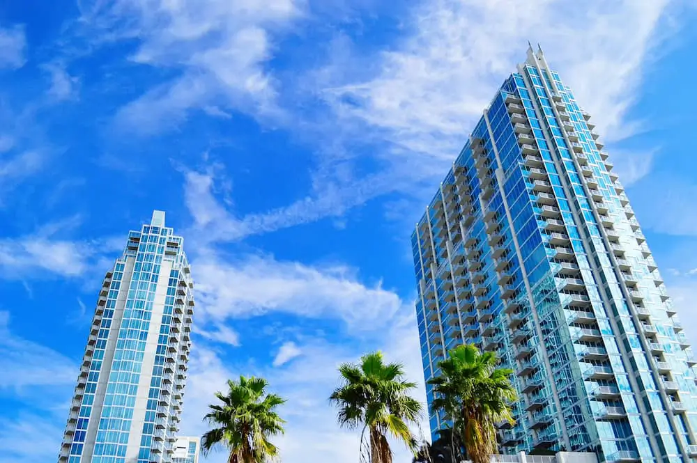 A tall condo complex with palm trees in the foreground