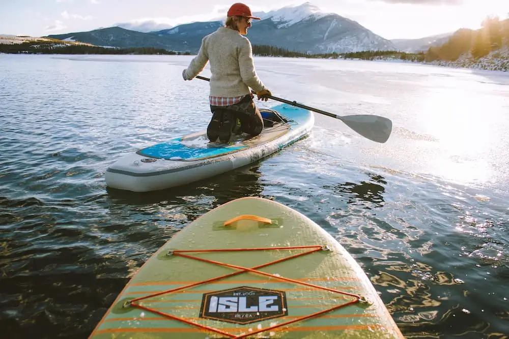 man paddling in front of a kayak