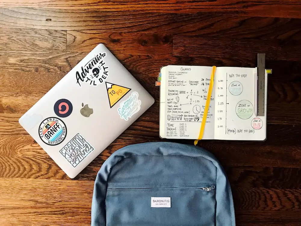 Items from the college packing list—a laptop, backpack and notebook