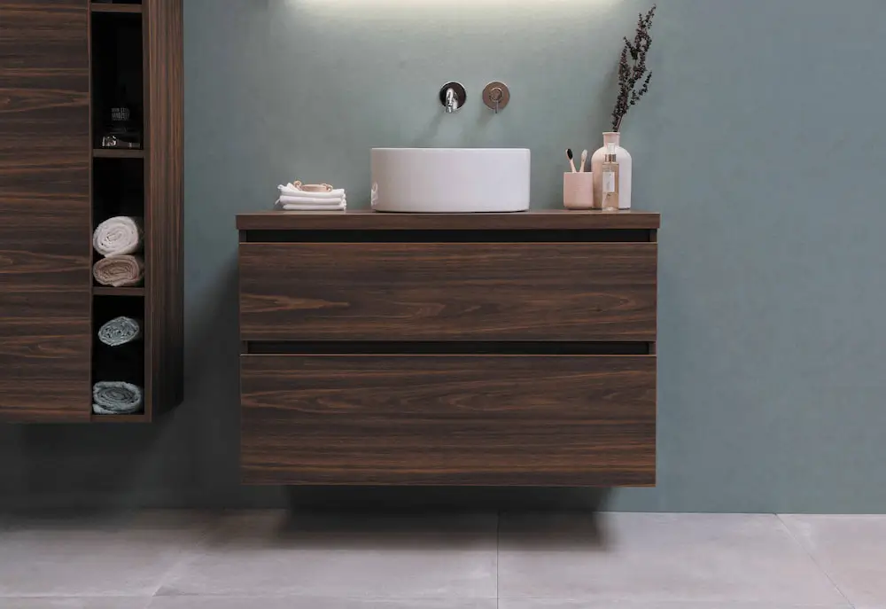 clean and decluttered dark wood bathroom vanity with white sink