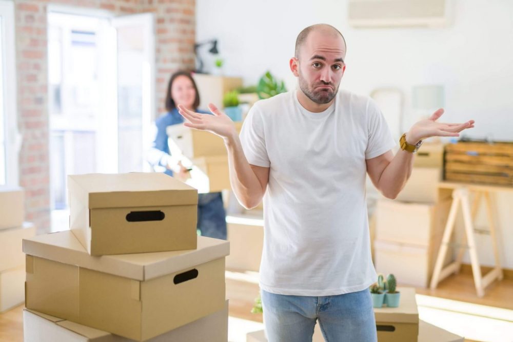 Shrugging man considers climate controlled storage before moving.