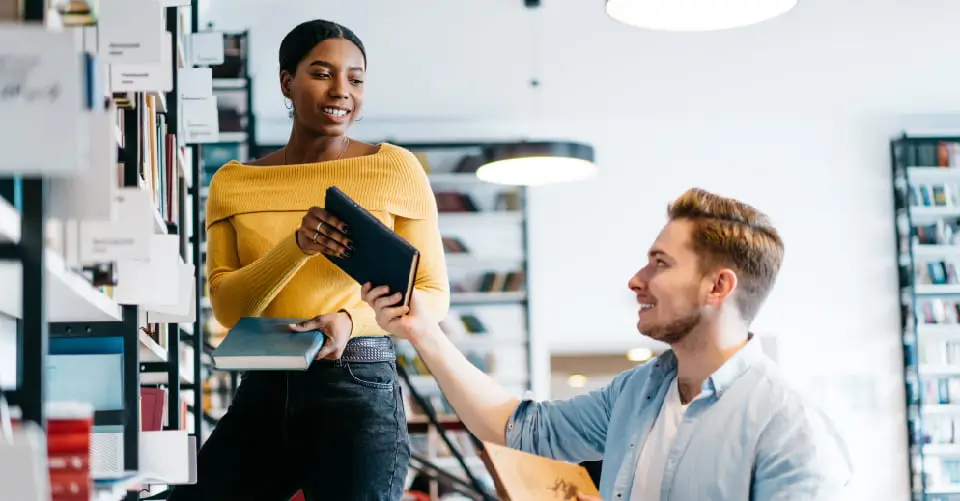 person handing someone else a book