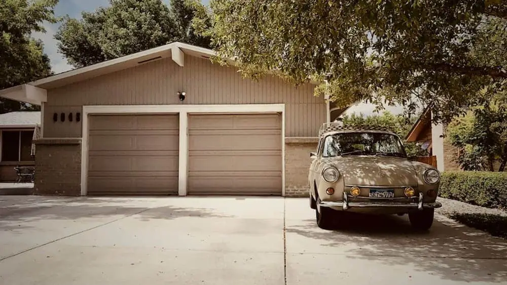 Garage with an old car in front.